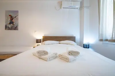 a white bed with two towels on top of it at Phoebe 3BR apartment in Neos Kosmos by ΜΡS in Athens