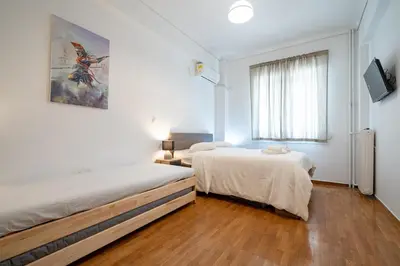 a white room with two beds and a window at Phoebe 3BR apartment in Neos Kosmos by ΜΡS in Athens