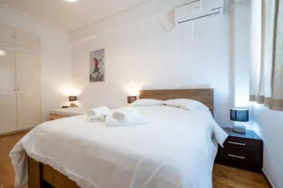 a white bedroom with a large bed with white sheets at Phoebe 3BR apartment in Neos Kosmos by ΜΡS in Athens