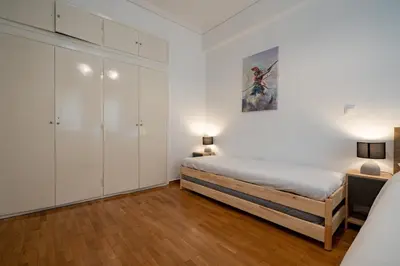 a bedroom with a bed and white cabinets at Phoebe 3BR apartment in Neos Kosmos by ΜΡS in Athens