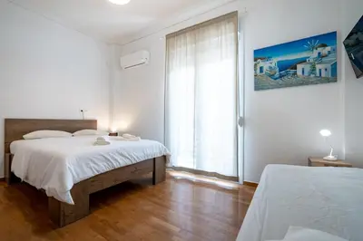a white bedroom with two beds and a window at Phoebe 3BR apartment in Neos Kosmos by ΜΡS in Athens