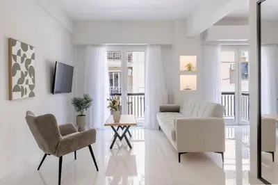 a white living room with a couch and chairs at Warm Athenian 2BR Apartment by Acropolis Hill by UPSTREET in Athens