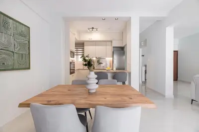 a dining room with a wooden table and white chairs at Warm Athenian 2BR Apartment by Acropolis Hill by UPSTREET in Athens
