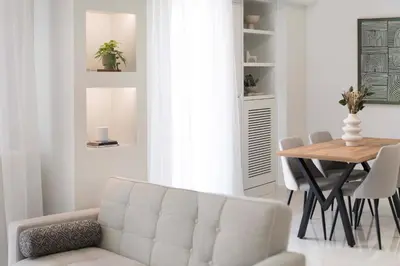 a living room with a white couch and a table at Warm Athenian 2BR Apartment by Acropolis Hill by UPSTREET in Athens
