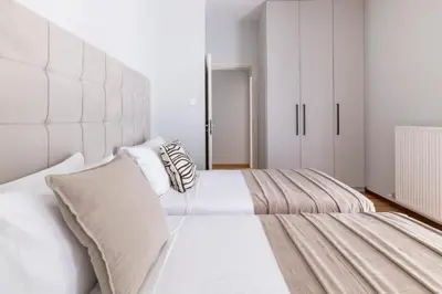 a bedroom with two beds and a large headboard at Warm Athenian 2BR Apartment by Acropolis Hill by UPSTREET in Athens