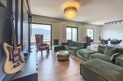a living room with a couch and a guitar at Phaedrus Living Apollo Skyview Penthouse in Athens