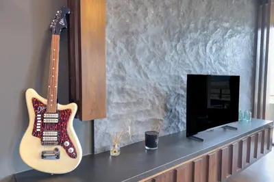 a guitar sitting on a counter next to a tv at Phaedrus Living Apollo Skyview Penthouse in Athens