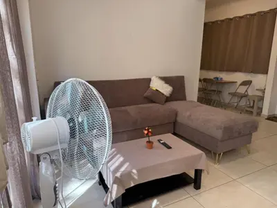 a living room with a couch and a fan at Alimos Cozy Apartment in Athens