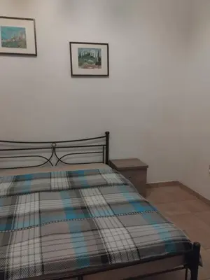 a bed in a bedroom with two pictures on the wall at Golden room 1 in Athens