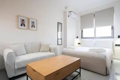 a bedroom with a bed and a couch and a table at LIV - Comfortable Athens Studios in Athens