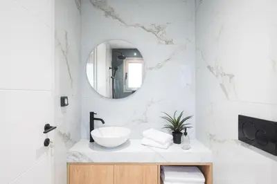 a white bathroom with a sink and a mirror at LIV - Comfortable Athens Studios in Athens