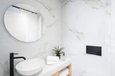 a white bathroom with a sink and a mirror at LIV - Comfortable Athens Studios in Athens