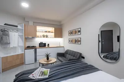 a bedroom with a bed and a chair and a kitchen at LIV - Comfortable Athens Studios in Athens