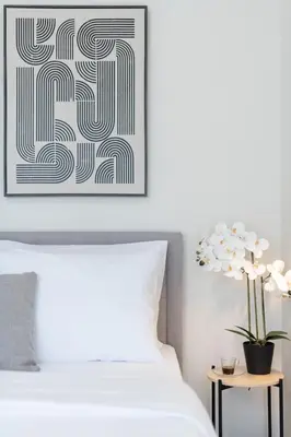 a bedroom with a white bed and a picture on the wall at LIV - Comfortable Athens Studios in Athens