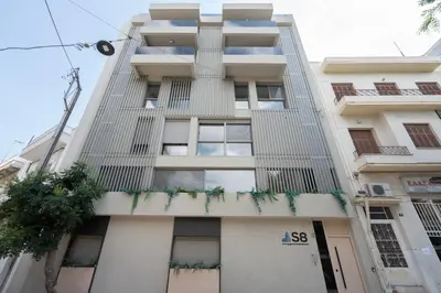 a tall white building with windows and plants at LIV - Comfortable Athens Studios in Athens