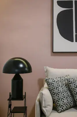 a black lamp sitting on a table next to a bed at Elegant Urban Stay in Piraeus in Piraeus