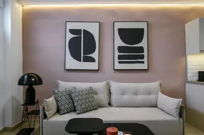 a living room with a couch and three pictures on the wall at Elegant Urban Stay in Piraeus in Piraeus