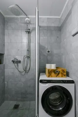 a washing machine in a bathroom with a shower at Elegant Urban Stay in Piraeus in Piraeus