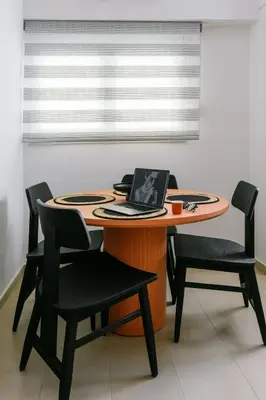 a table with chairs and a laptop on it at Elegant Urban Stay in Piraeus in Piraeus