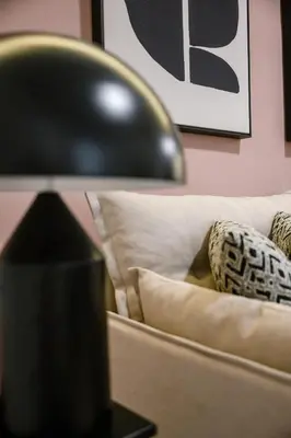 a black lamp sitting next to a couch with pillows at Elegant Urban Stay in Piraeus in Piraeus