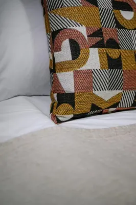 a pillow sitting on top of a bed at Elegant Urban Stay in Piraeus in Piraeus