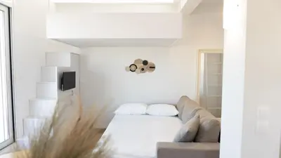 a white living room with a couch and a tv at 360 Athens Rooftop Nest, 300m from Metro Station, Acropolis View in Athens
