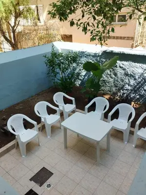 a group of white chairs and a table on a patio at Golden room 3 in Athens