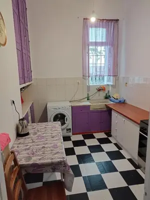 a kitchen with purple cabinets and a checkered floor at Golden room 3 in Athens