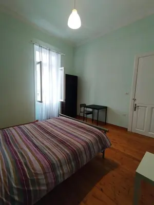 a bedroom with a bed with a striped blanket on it at Golden room 6 in Athens