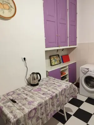 a kitchen with purple cabinets and a table and a washing machine at Golden room 6 in Athens