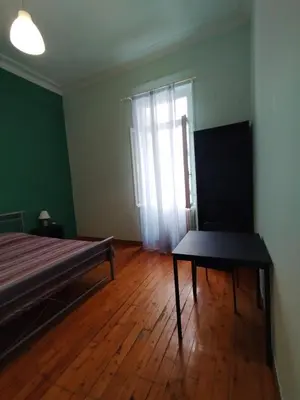 a bedroom with a bed and a table and a window at Golden room 6 in Athens