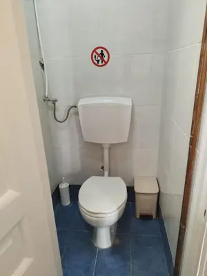 a small bathroom with a toilet and a sign on the wall at Golden room 6 in Athens