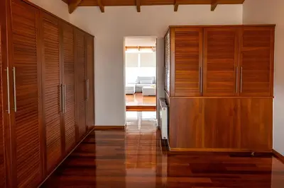 a hallway with wooden cabinets and a living room at Olive Grove Villa in Koropíon