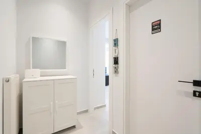 a white bathroom with a sink and a mirror at 2BR Family Apartment With Playroom-Arcade, 2 Bathrooms & 2 Kitchens in Athens