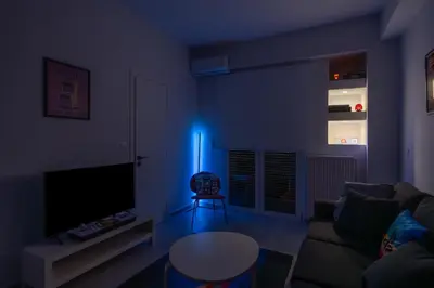 a blue light in a living room with a couch and a table at 2BR Family Apartment With Playroom-Arcade, 2 Bathrooms & 2 Kitchens in Athens