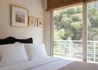 a bedroom with a bed and a large window at Vouliagmeni Exclusive Residence in Athens