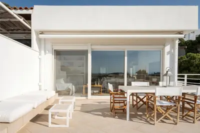 a white patio with a white table and chairs at Vouliagmeni Exclusive Residence in Athens