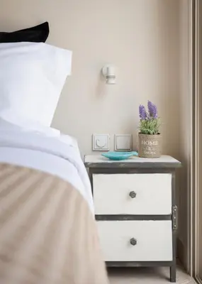 a bed with a nightstand with a plant on it at Vouliagmeni Exclusive Residence in Athens
