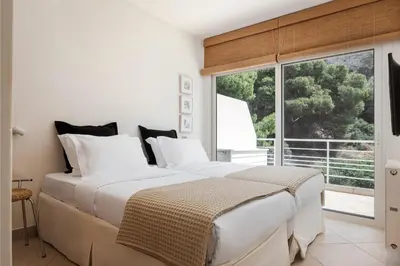 two beds in a bedroom with a large window at Vouliagmeni Exclusive Residence in Athens