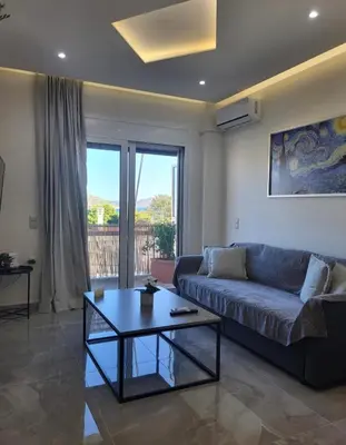 a living room with a couch and a coffee table at Luxury apartment center of Varkiza Resort in Vari