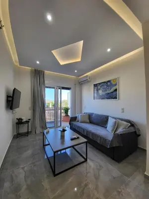 a living room with a couch and a table at Luxury apartment center of Varkiza Resort in Vari