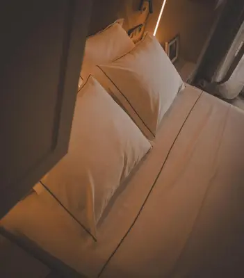 a bed with white sheets and pillows in a room at Aura and Luxury in Athens
