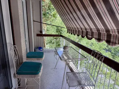 a balcony with two chairs and a glass table at Neos Kosmos Family Apartment in Athens