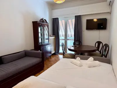 a living room with a bed and a table and a couch at Neos Kosmos Family Apartment in Athens