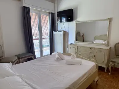 a bedroom with a large white bed with towels on it at Neos Kosmos Family Apartment in Athens