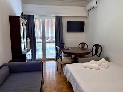 a hotel room with two beds and a table and a table at Neos Kosmos Family Apartment in Athens