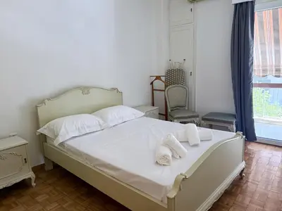 a bedroom with a white bed with towels on it at Neos Kosmos Family Apartment in Athens