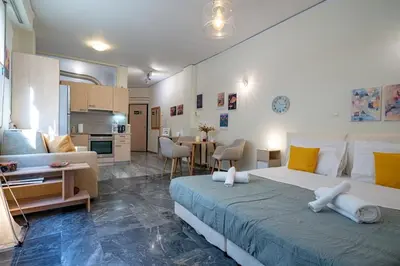a bedroom with a large bed and a living room at Plaka City Studio - Walk to Syntagma by ΜΡS in Athens