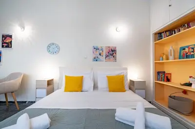 a bedroom with a large white bed with yellow pillows at Plaka City Studio - Walk to Syntagma by ΜΡS in Athens