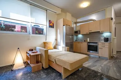 a living room with a couch and a kitchen at Plaka City Studio - Walk to Syntagma by ΜΡS in Athens